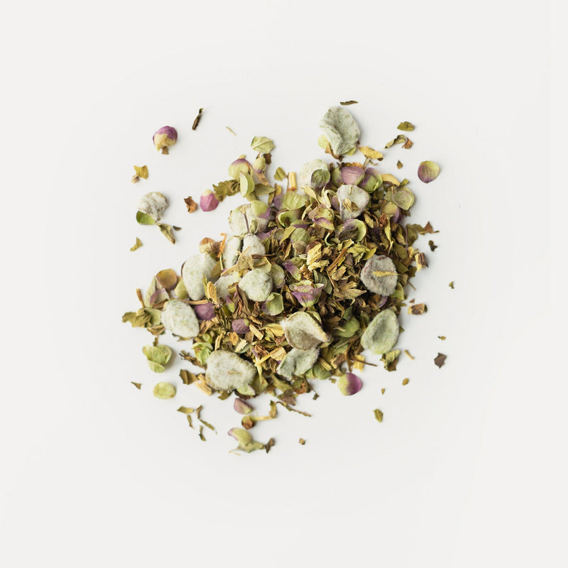 A blend of Mediterranean herbs and spices, featuring green leaves, purple buds, and light pods including the aromatic Dittany of Crete by Rishi Tea & Botanicals, is displayed on a plain white background.